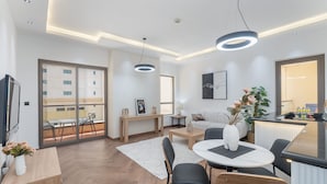 Un salon moderne avec un coin repas, de grandes fenêtres et un balcon.