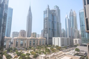 A cityscape with modern high-rise buildings, including a prominent skyscraper with 'Ellington' written on it.