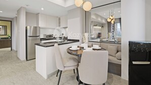 Una cocina moderna con una isla central, electrodomésticos de acero inoxidable y un dispensador de agua.