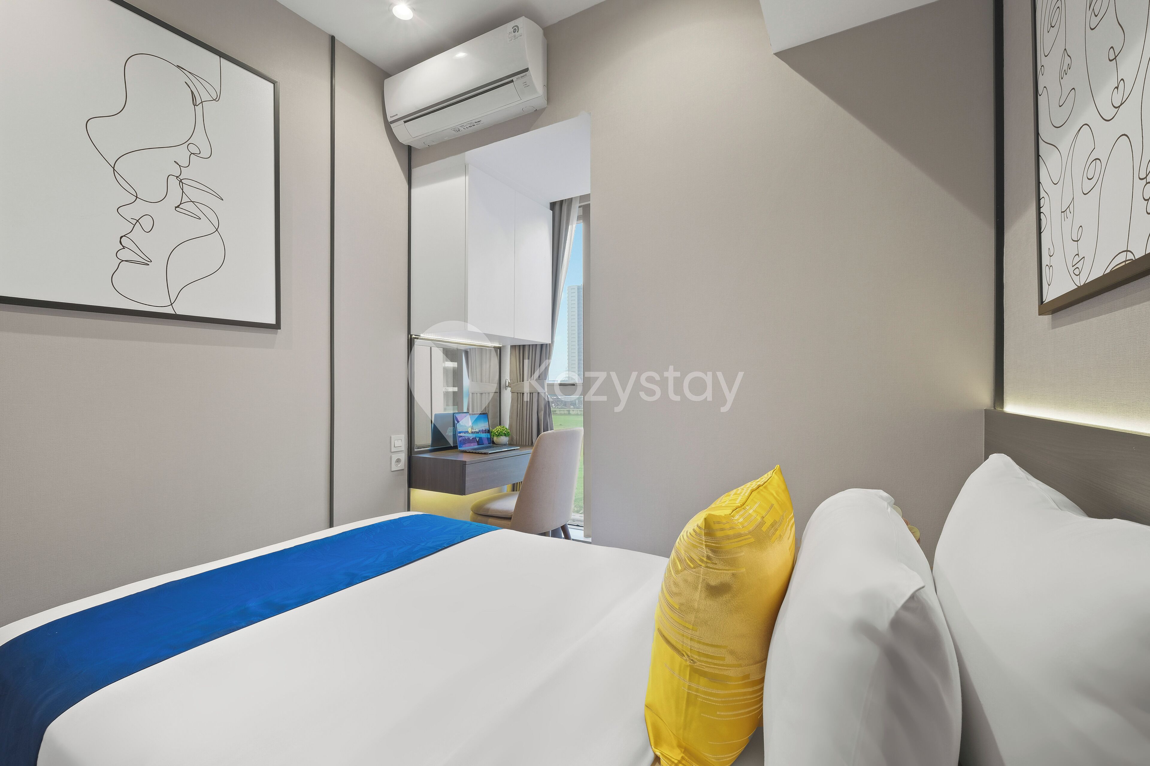 Una habitación de hotel moderna con una cama, un escritorio y un equipo de aire acondicionado.