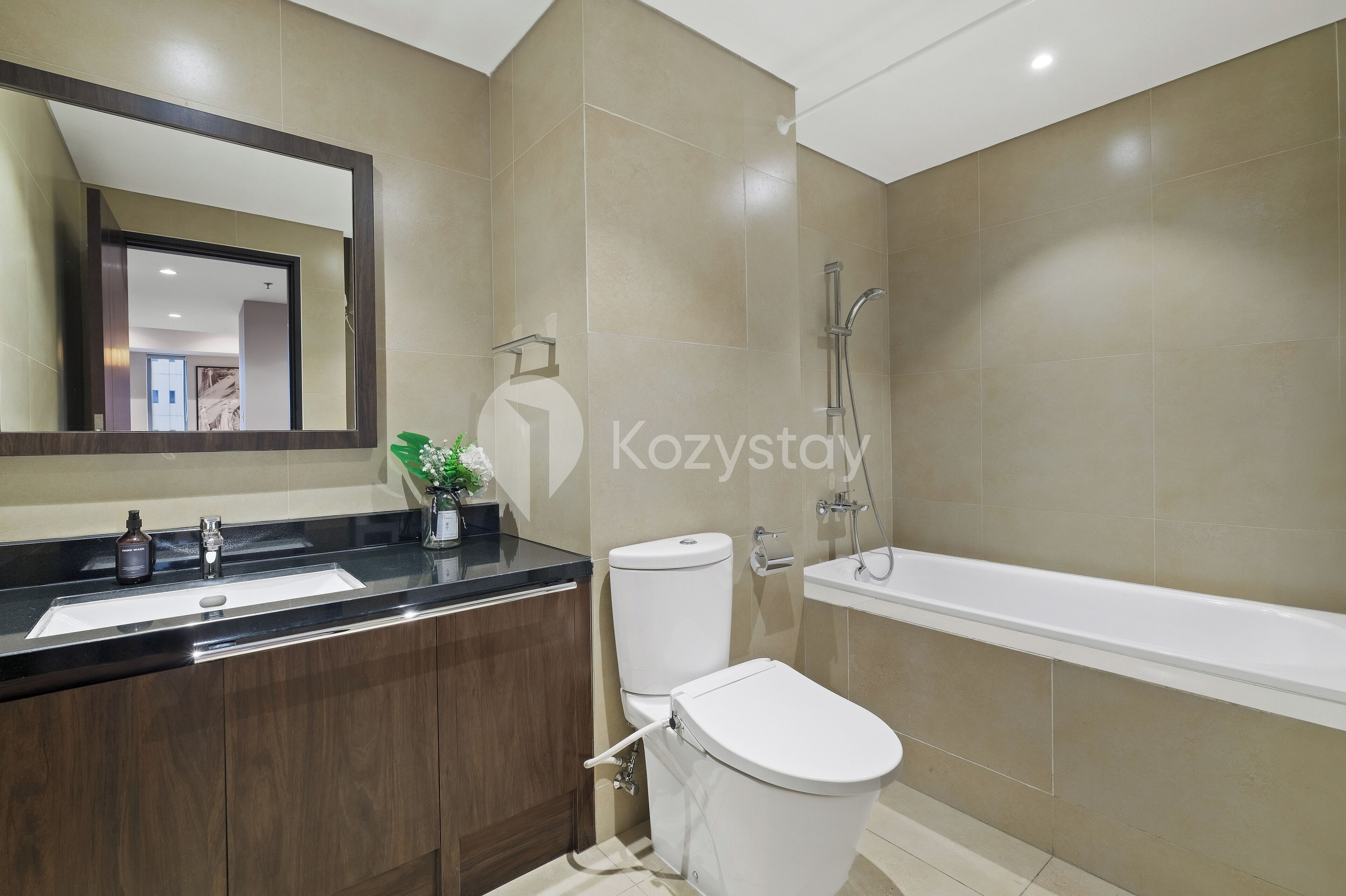 A modern bathroom with a sink, toilet, and bathtub.