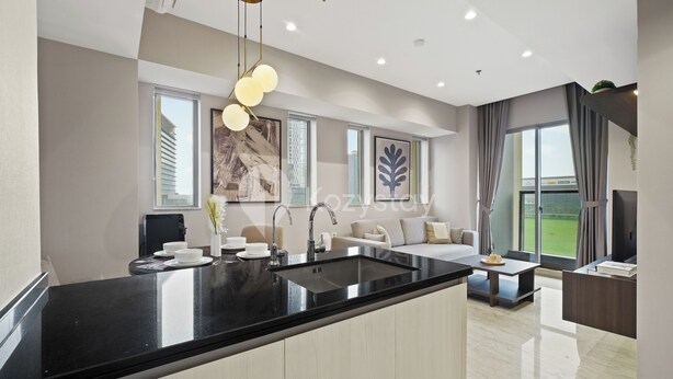 Una cocina moderna con encimera negra, un lavabo integrado y una zona de comedor con mesa y sillas.