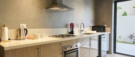Una cocina moderna con una campana de acero inoxidable, un horno empotrado y un lavavajillas.