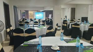 A conference room with multiple round tables, each with water bottles and notebooks. - Downtown ecopark hotel (Kitui)