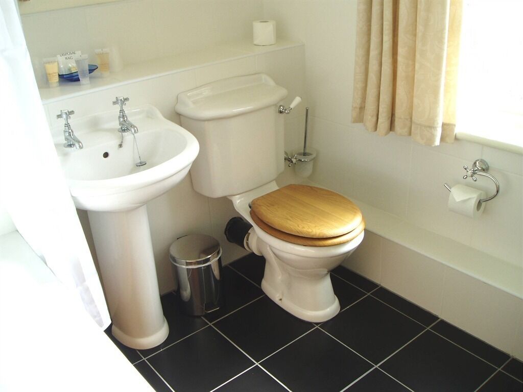 A bathroom with a white toilet, a sink, and a bathtub.
