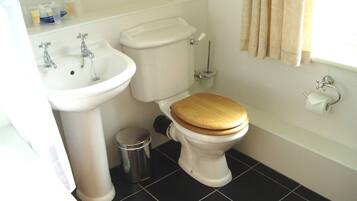 A bathroom with a white toilet, a sink, and a bathtub.