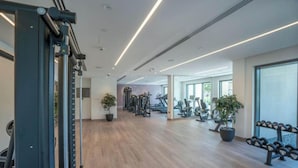 A modern gym with cardio machines, weightlifting equipment, and potted plants. - Lux 2BR Downtown Enjoy Full Burj Khalifa View (Dubai)