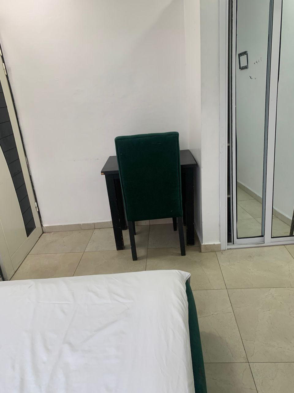 Un dormitorio con cama, escritorio y silla.