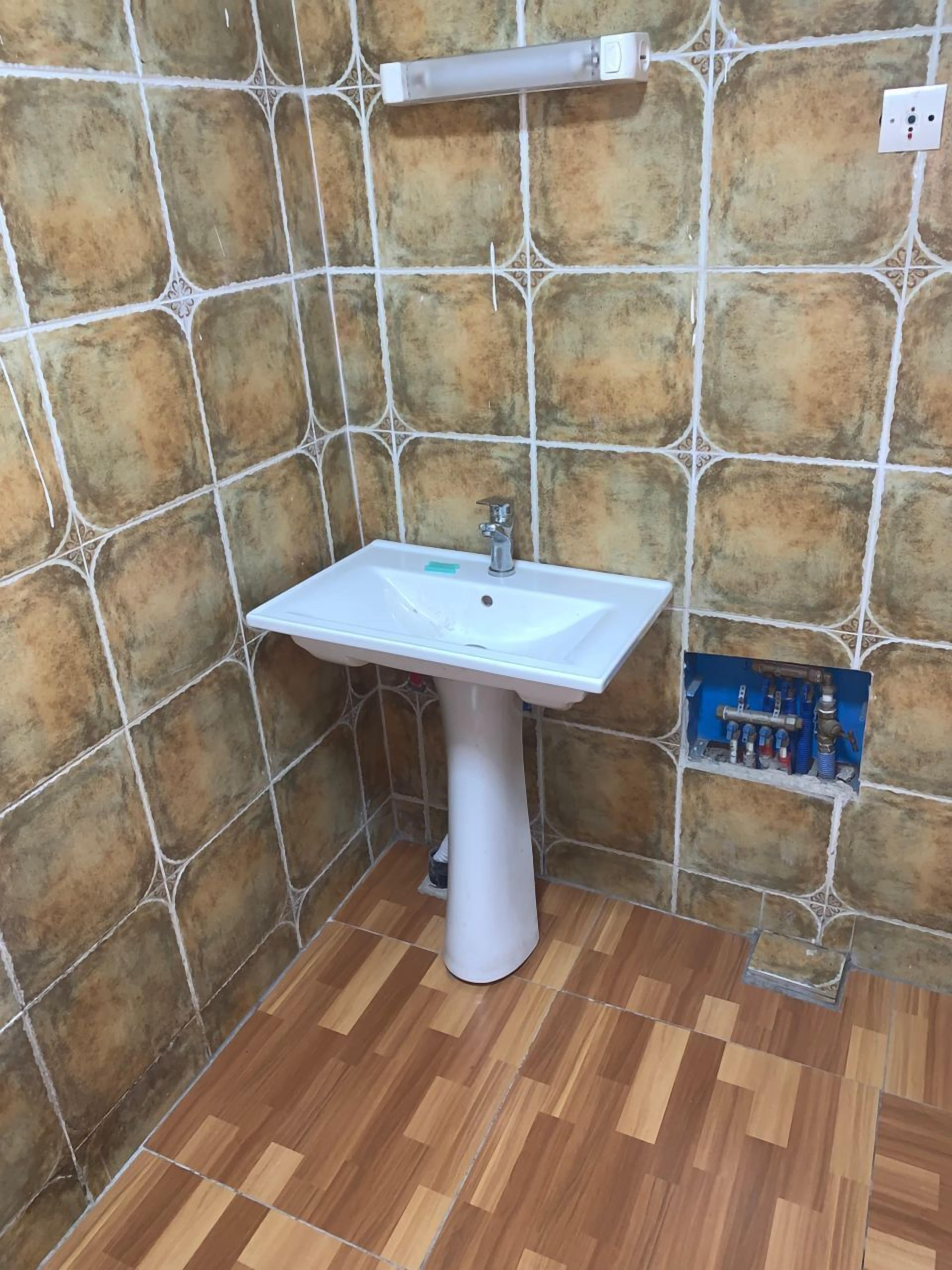 Bañera con ducha, pantuflas, toallas, jabón