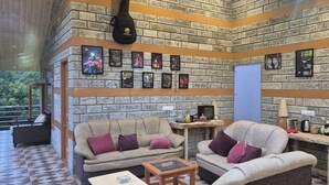 Una sala de estar acogedora con paredes de ladrillo, dos sofás con cojines, una mesa de centro y cuadros en la pared.