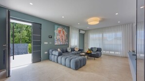 Un salon moderne avec un canapé d’angle, une table basse et un tableau accroché au mur.