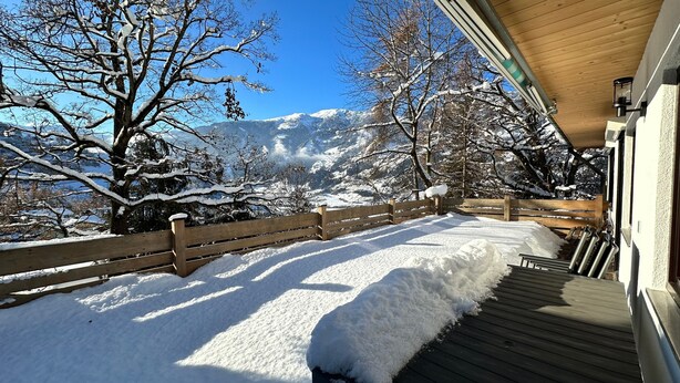 A wooden deck with snow-covered steps leading to a building, surrounded by snow-laden trees and mountains in the background. - Holiday Home 'Anton' with Mountain View, Private Terrace and Wi-Fi (Gerlosberg)