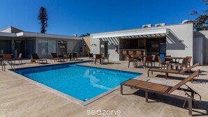 Una piscina con lettini e un'area bar.