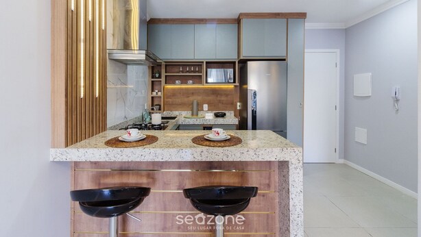 Una cucina moderna con ripiani in granito, mobili in legno ed elettrodomestici in acciaio inossidabile.