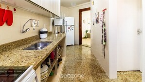 A kitchen with granite countertops, stainless steel sink, white cabinets, and a refrigerator. - Beautiful apt W/suite 300m From Forte Beach Bfc301 (Cabo Frio)