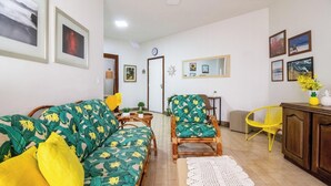 A living room with a sofa, chairs, a small table, a mirror, and a cabinet. - Beautiful apt W/suite 300m From Forte Beach Bfc301 (Cabo Frio)