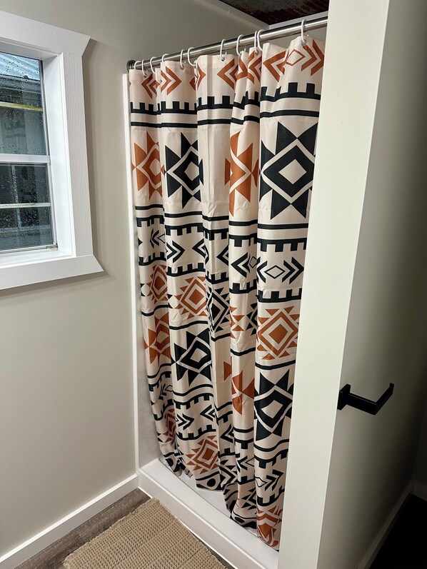 Un baño con cortina de ducha de estampado geométrico.