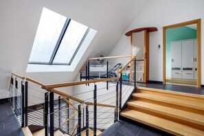 Ein modernes Interieur mit Treppe, Oberlicht und Blick auf einen Raum mit Schränken.