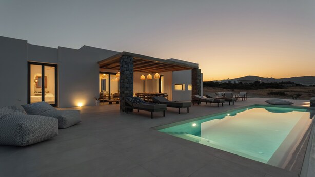 A modern outdoor pool area with lounge chairs and a covered seating area. - Near Naousa |3BR Villa| Private Pool |Villa Candia (Paros)