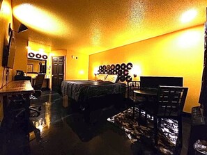 A room with a bed, a desk, a chair, a wall-mounted record player, and a door. - Southern Soho Boutique Hotel (Oxford)