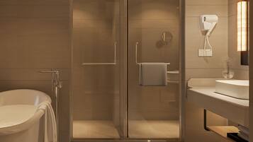 Une salle de bain moderne dotée d’une douche à parois de verre, d’une baignoire sur pieds et d’un meuble-lavabo avec miroir.