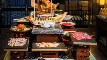 A buffet with various dishes, including a large roasted pig, arranged on a marble table.