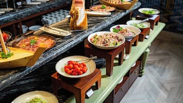 A buffet with various dishes and a large roasted pig centerpiece.