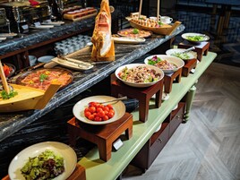 A buffet with various dishes and a large roasted pig centerpiece.