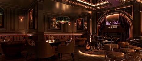 Un espace bar à l’ambiance jazz, avec un piano, une batterie et des espaces aménagés pour s’asseoir.