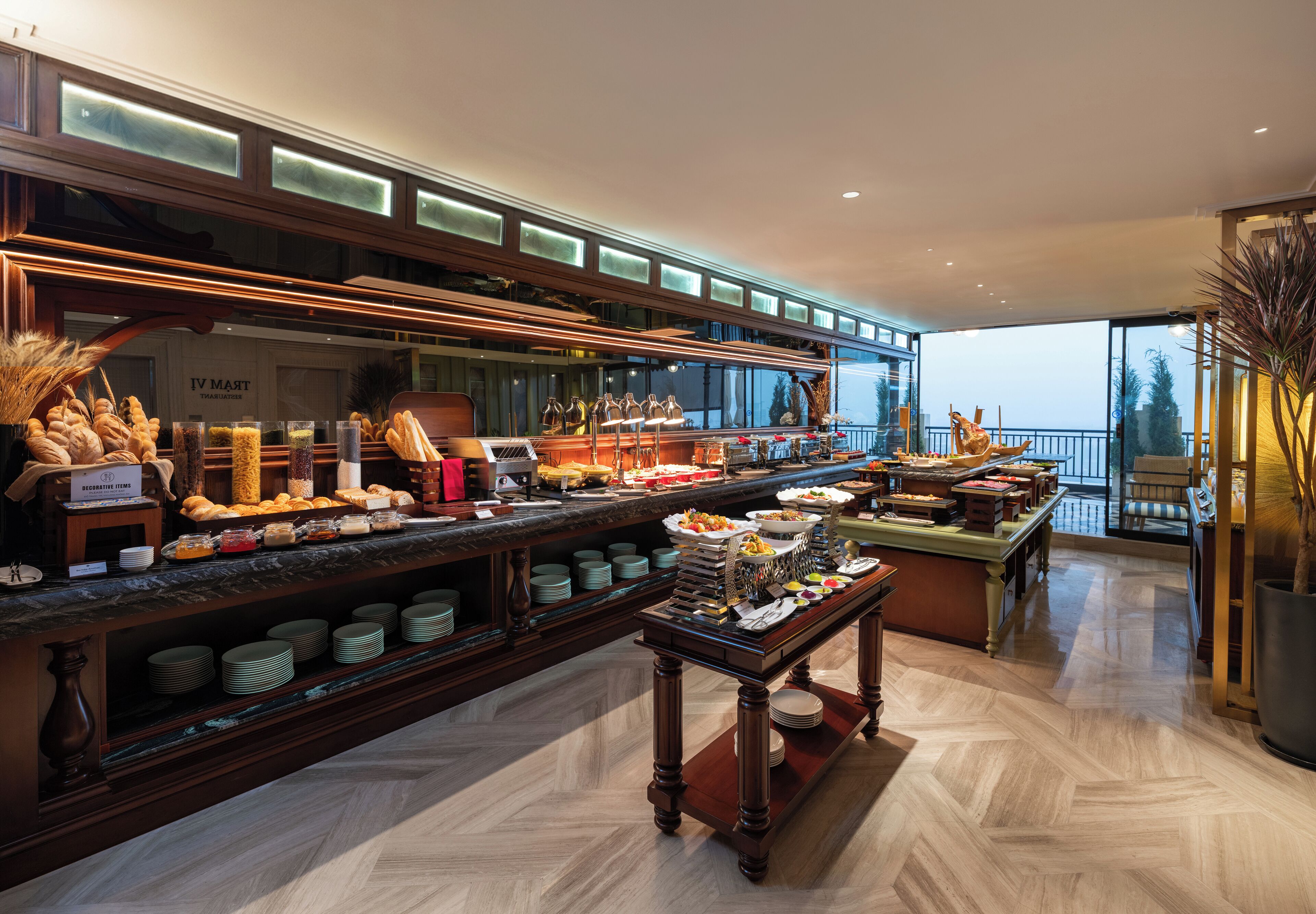 Zona de buffet con diferentes opciones de comida y vistas al exterior.