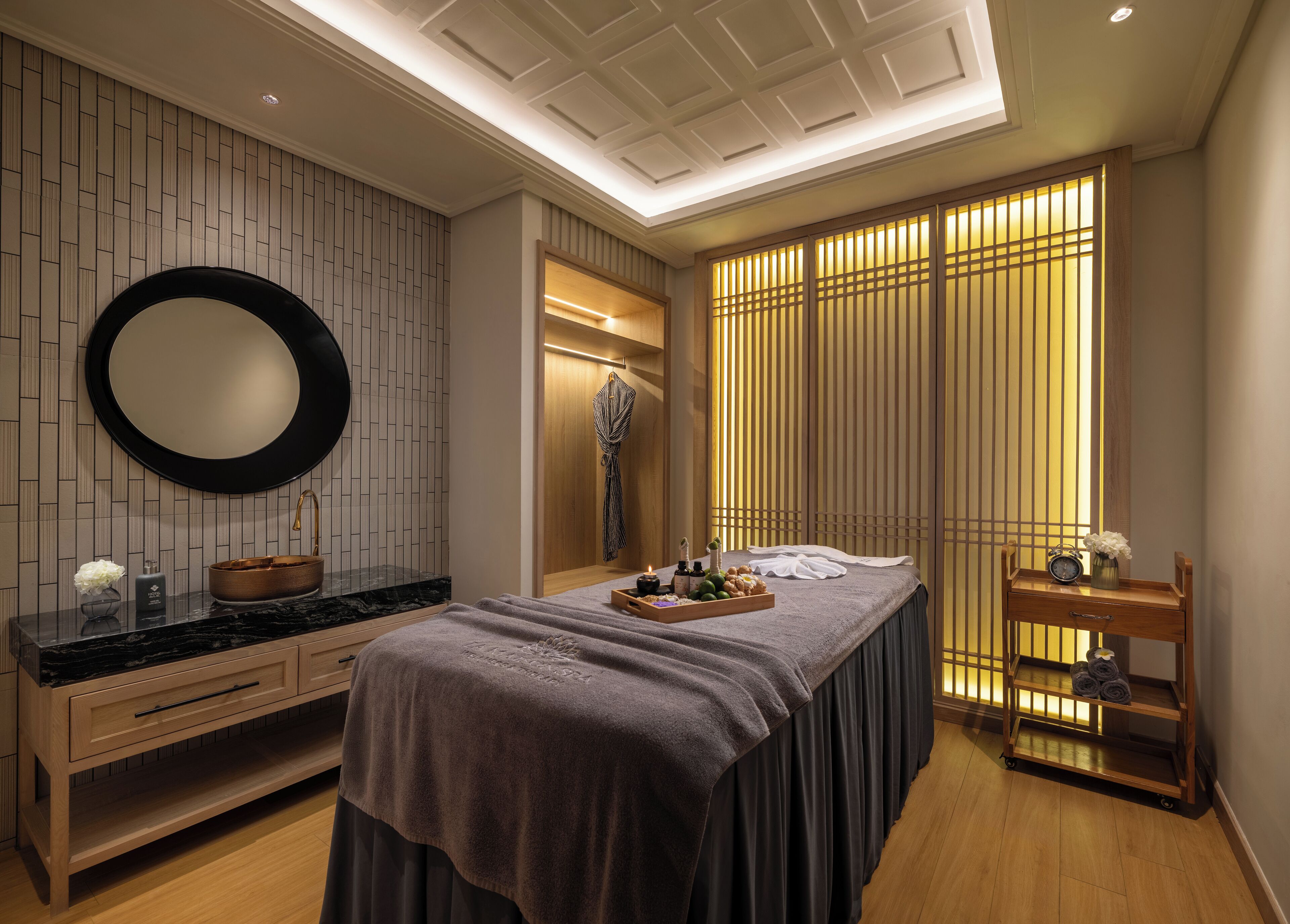 A modern bedroom with a large bed, a vanity with a mirror, and a wooden dresser.