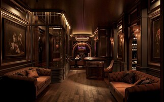 A luxurious interior with a bar area, leather sofas, and framed artwork.