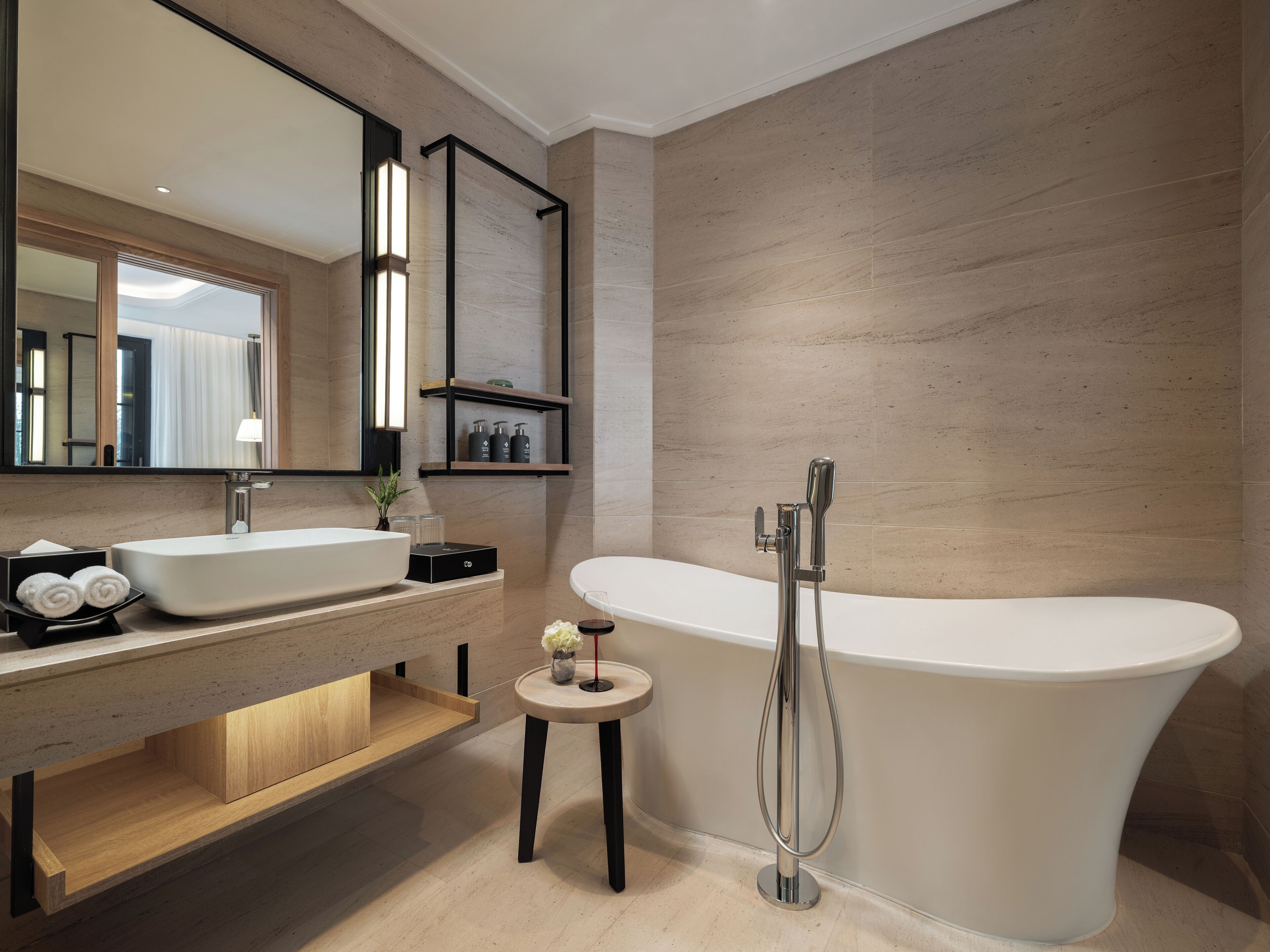 A modern bathroom with a freestanding bathtub, a double sink vanity, and a small stool.