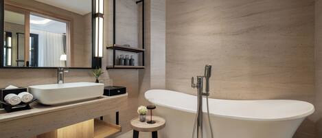 A modern bathroom with a freestanding bathtub, a double sink vanity, and a small stool.