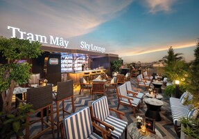 A rooftop bar area with seating and a bar, named 'Tram May Sky Lounge'.