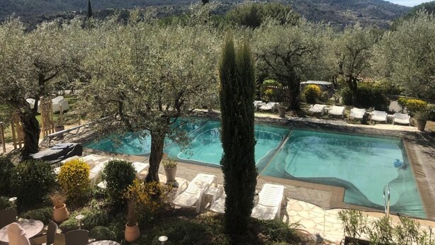 A pool area with lounge chairs and a view of mountains. - Hôtel la Picholine en Provence (Nyons)