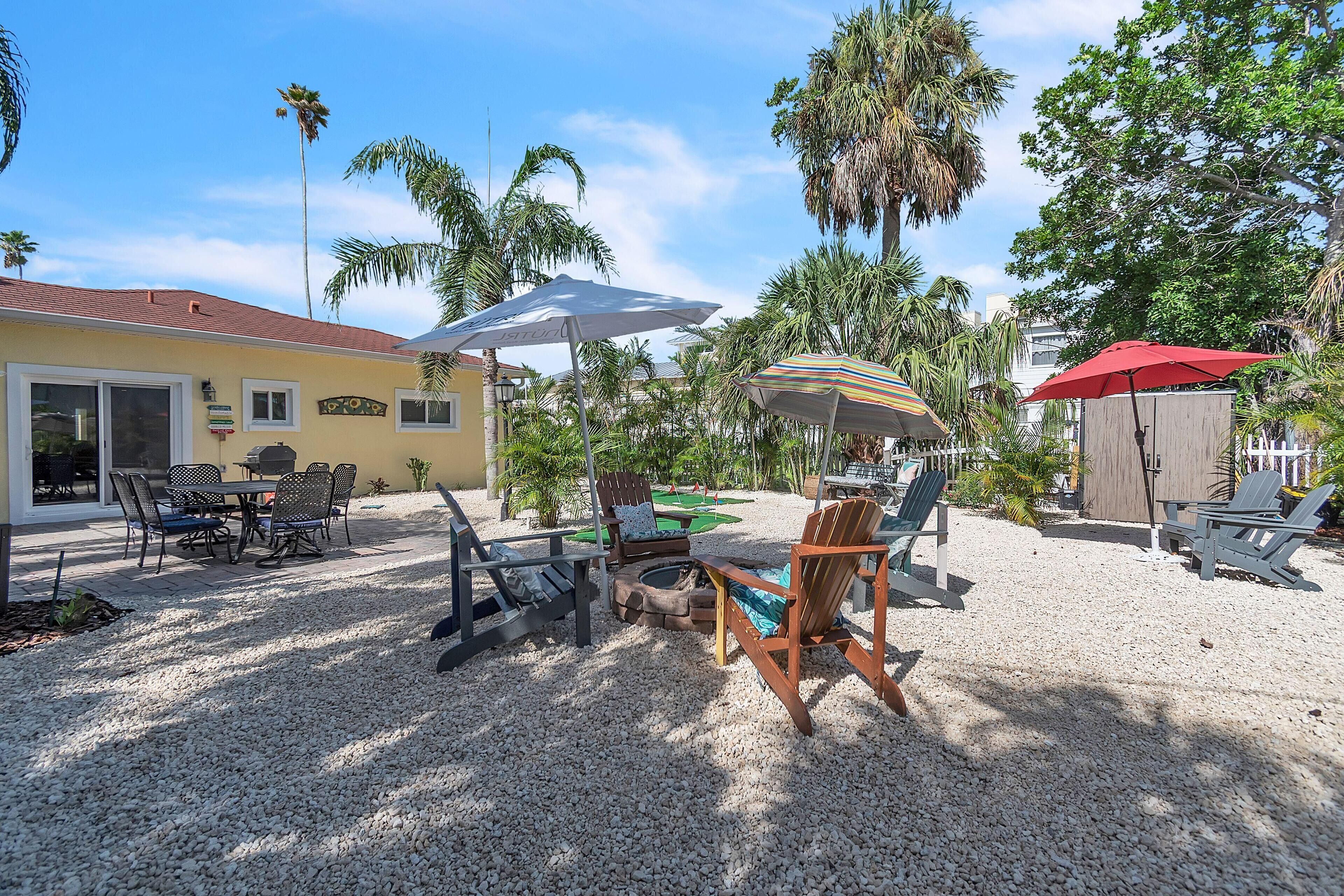 A patio area with outdoor furniture, a pool table, and a tiki bar.