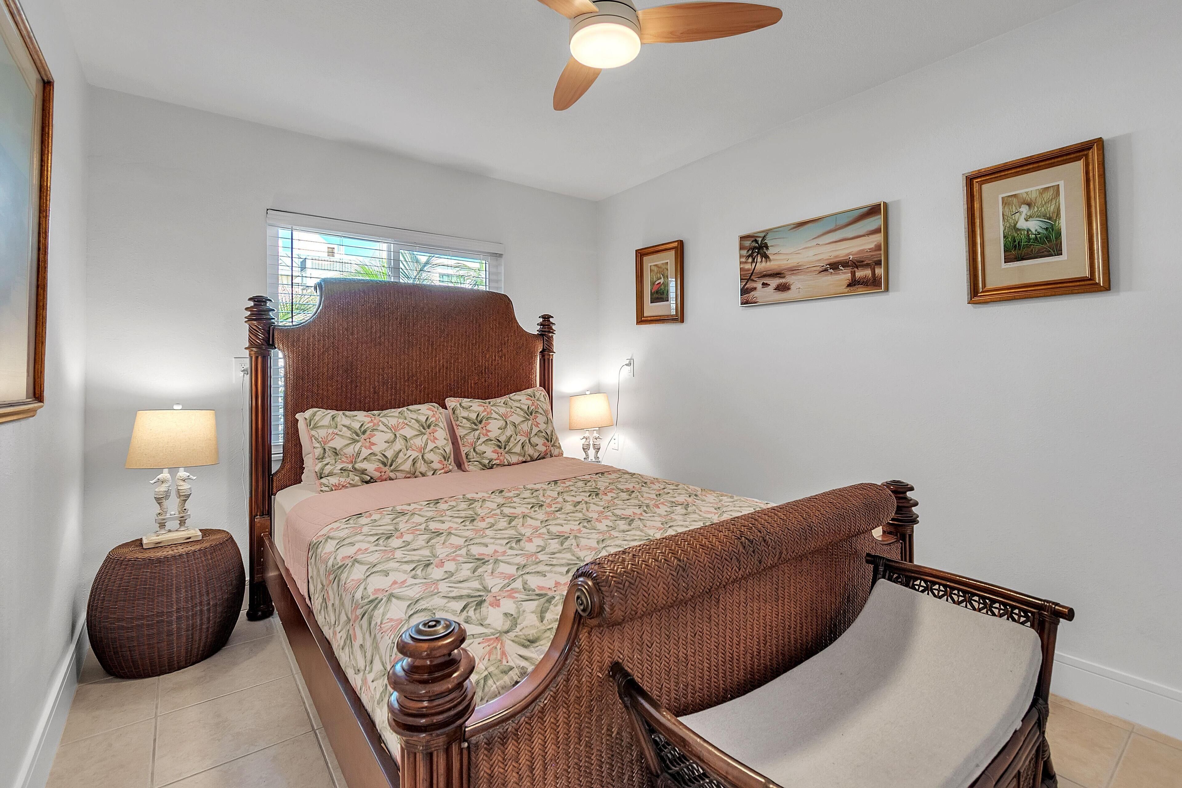 Une chambre à coucher avec un lit à baldaquin, deux lampes de chevet et des œuvres d’art encadrées accrochées aux murs.