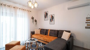 Una sala moderna con un sofá seccional, una mesa de centro y una alfombra estampada.