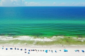 Une plage à l’eau turquoise et limpide, bordée d’un rivage sablonneux.