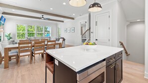 A modern kitchen with a large island, wooden chairs, and pendant lighting. - 6 Ensuite Bedrooms, Pool, Close to Beach, Luxury (Santa Rosa Beach)