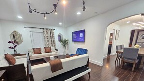 Un salon moderne avec un canapé, une table basse et un coin repas.
