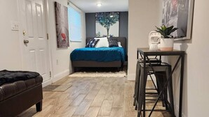 Un dormitorio moderno con una cama grande, un escritorio y una silla.