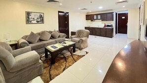 A spacious living room with a sofa set, a coffee table, and a rug.