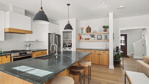 A modern kitchen with a large island, wooden cabinets, stainless steel appliances, and pendant lighting. - Upscale 4Bdrm Getaway with Hot Tub, Near Stowe Village & Trails (Stowe)