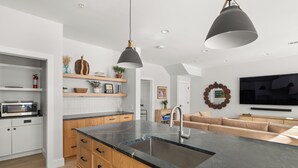 A modern kitchen with a large island, wooden cabinets, and a built-in microwave. - Upscale 4Bdrm Getaway with Hot Tub, Near Stowe Village & Trails (Stowe)