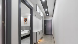 A hallway with a bed, wardrobe, and a door. - Maxi Prime Homes (Antalya)
