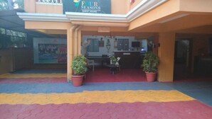 A guest house with a reception desk, two potted plants, and a colorful tiled entrance. - Four Seasons GuestHouse (Utorda)