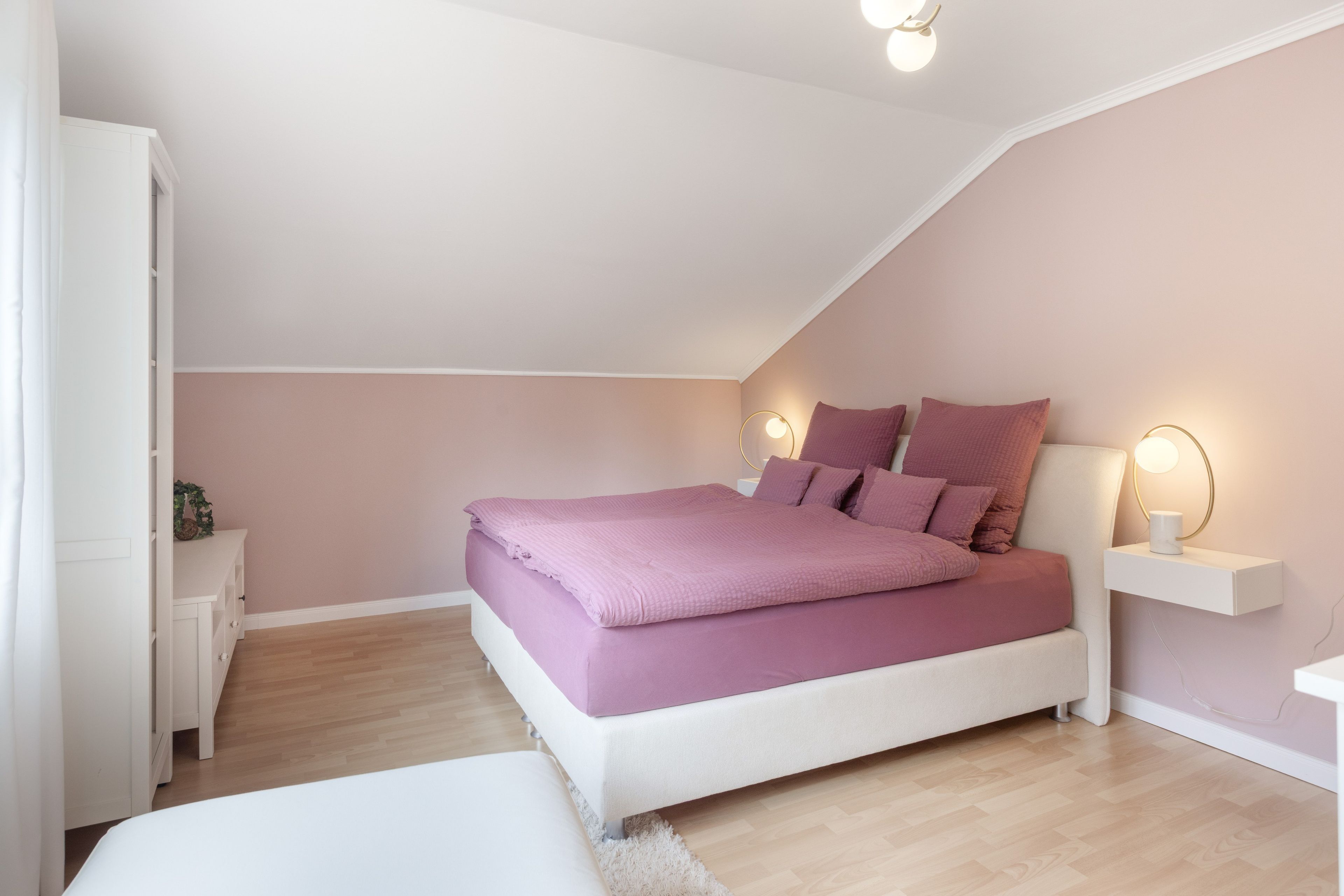 Un dormitorio con cama, mesitas de noche y un velador.