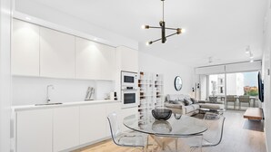 A modern kitchen with white cabinetry, a glass dining table, and a built-in oven. - Ref. 567641 (Motril)